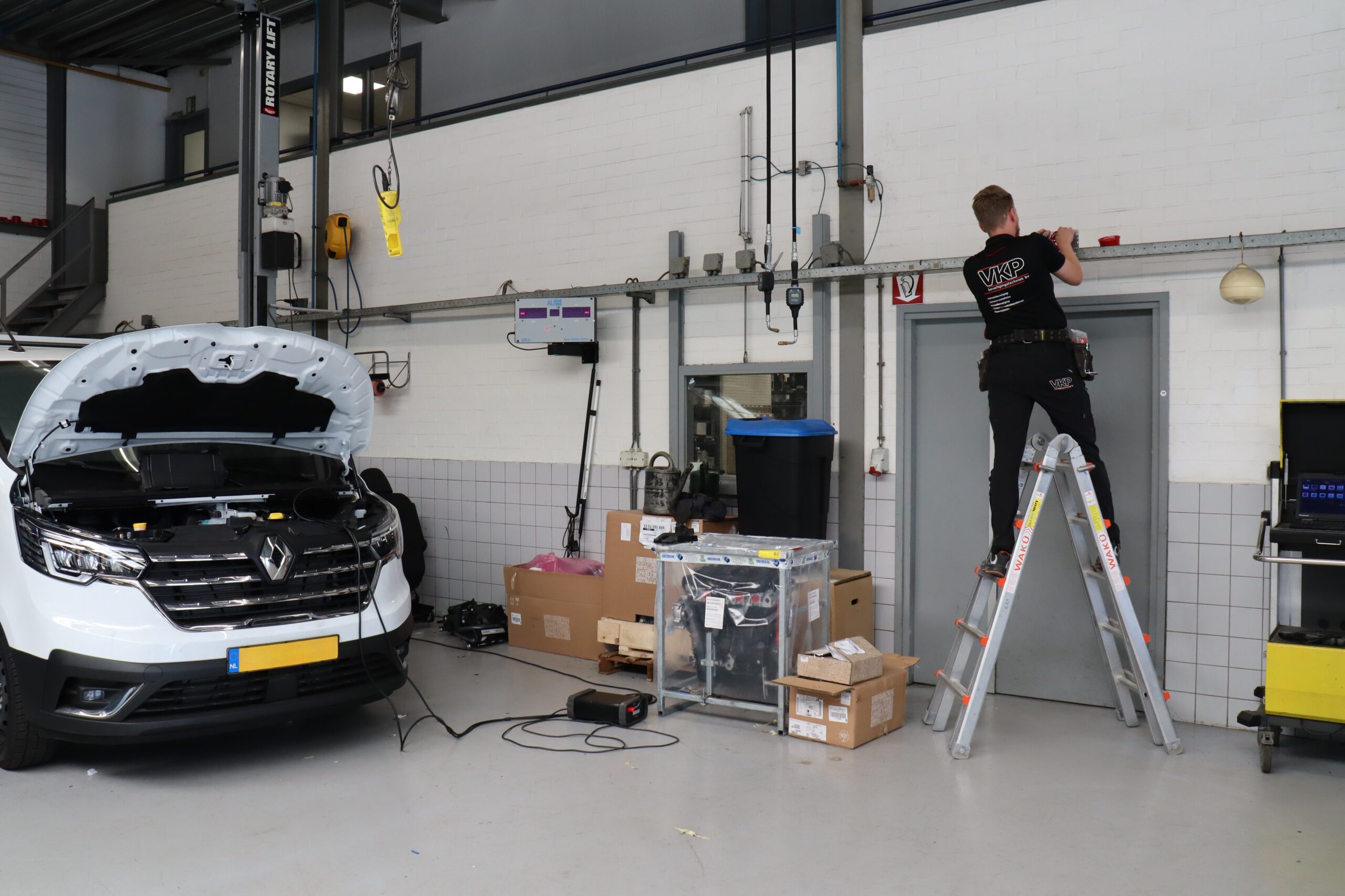 Monteur van VKP Beveiliging staat op ladder tijdens project bij Hans Jongerius